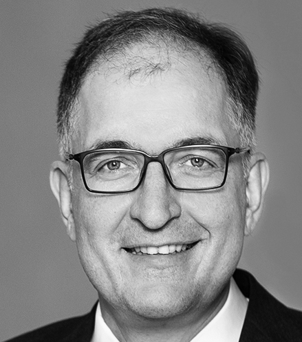 Black-and-white portrait photograph of a man wearing glasses